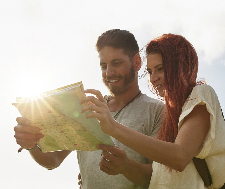 Two people outdoors looking at a paper map