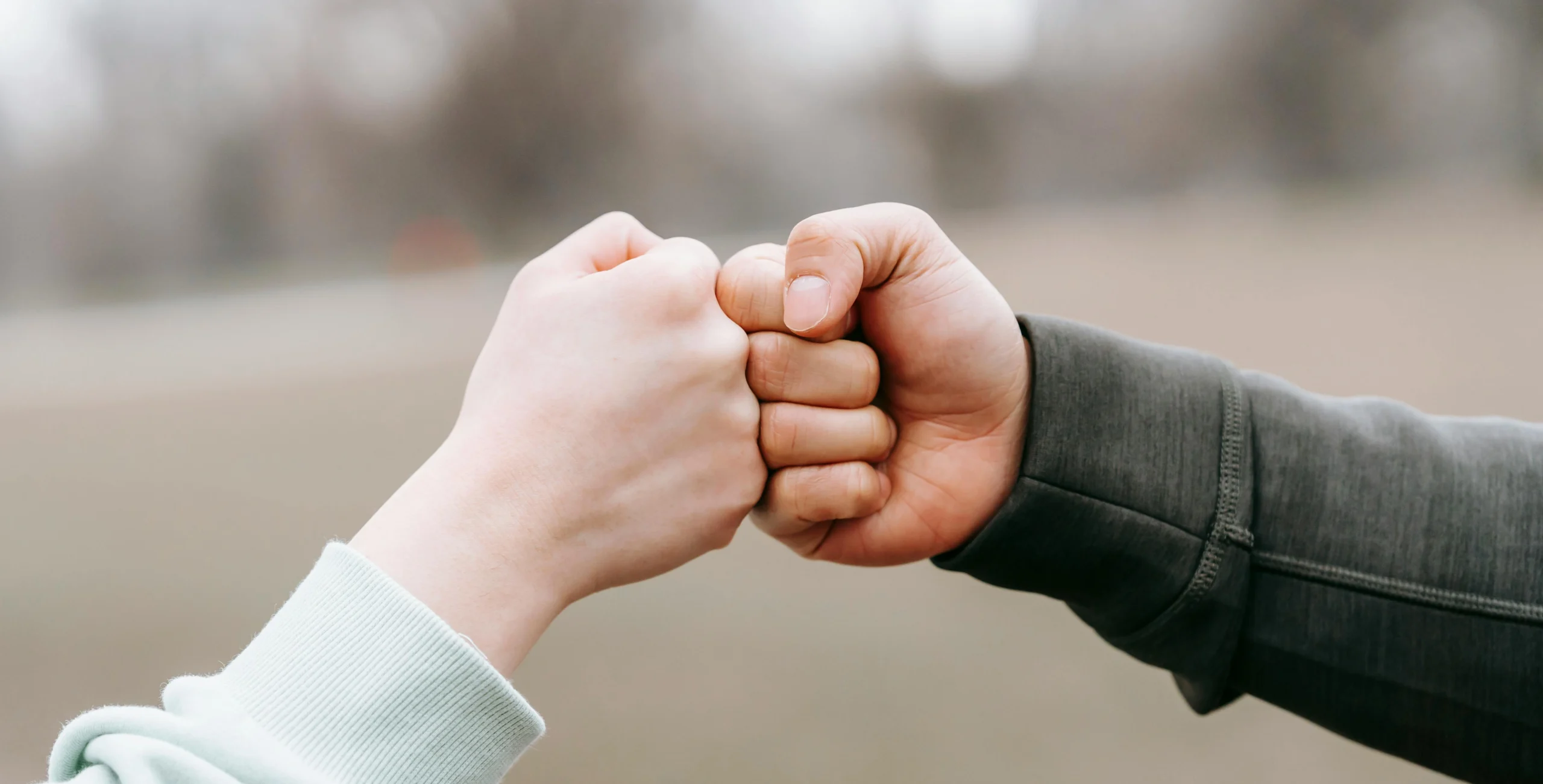 two people's hands doing a fist bump