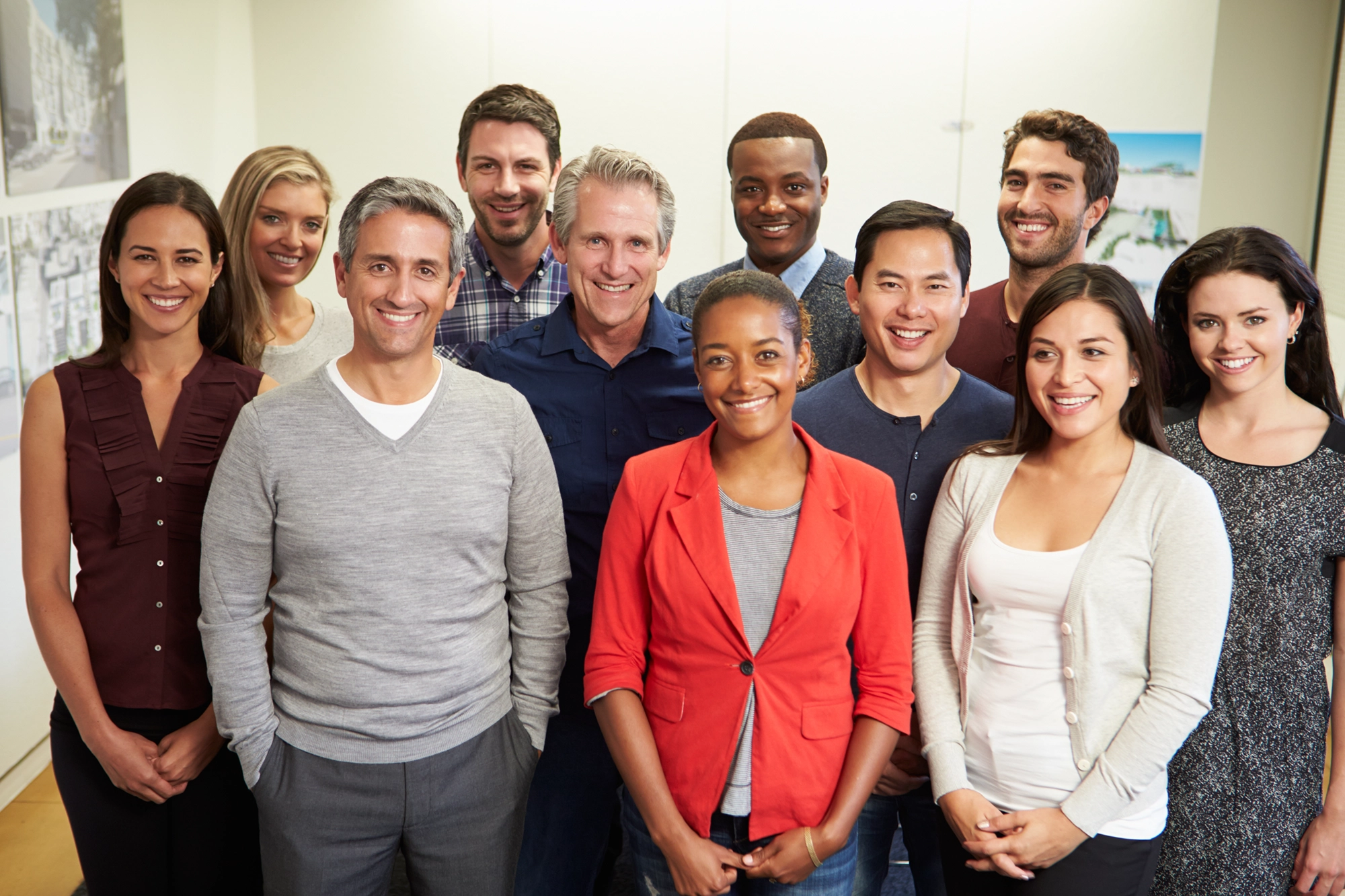 a group of 11 smiling people ranging in age and race