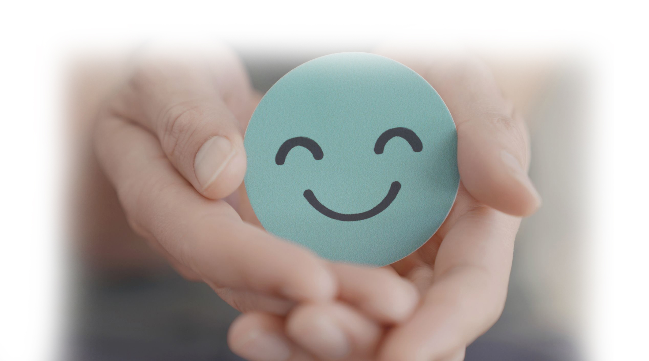 hands holding a blue smiley face icon