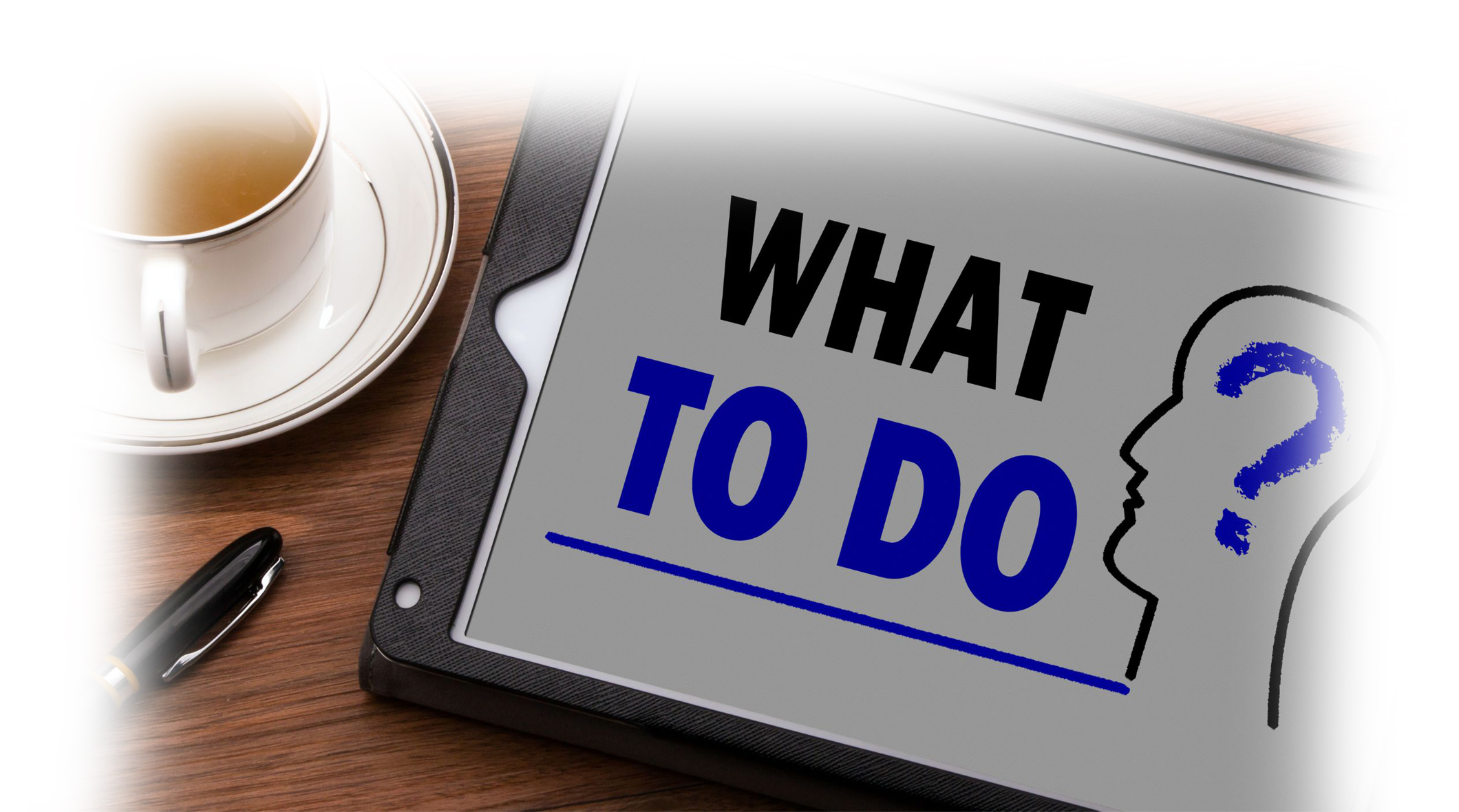 on a table next to a coffee is a tablet with the words what to do and a question mark inside the shape of a head